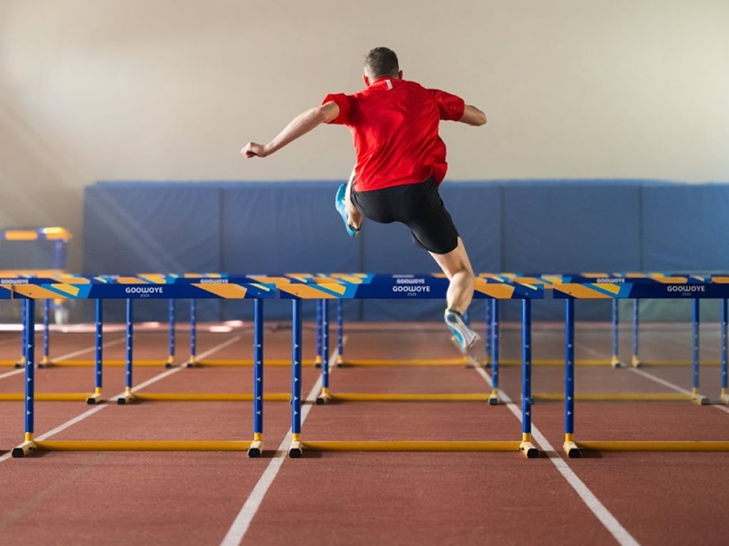 runner overcoming hurdle
